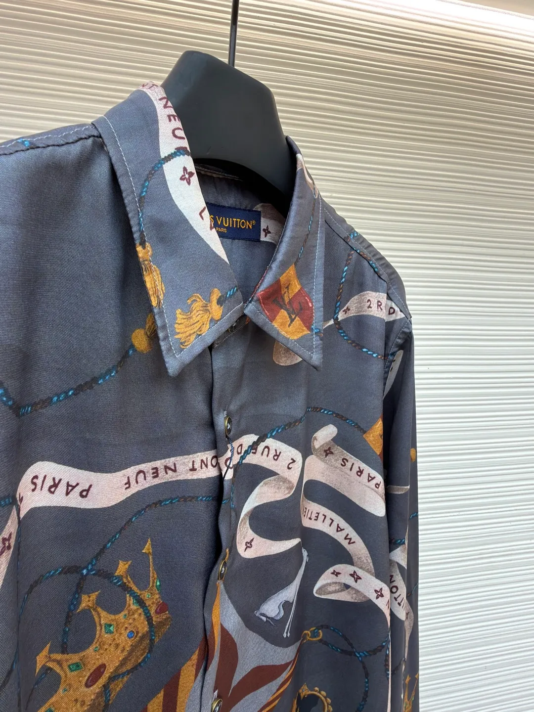 LOUIS VUITTON lapel printed mulberry silk shirt ●Original version: Purchased and developed for 17000 ●Item number: 1682218-A85 ●Fabric: worsted mercerized imitation Tencel fabric ●Technology: made by positioning cutting machine ●Color: gray ●Version: fitted version ●Weight: about 190 grams ●Size: S-M-L-XL ●Description: This printed long-sleeved shirt is made of 19mm mulberry silk and cotton blended fabric, which is made through high-density weaving process. The fabric combines the smooth luster of silk with the crisp and breathable characteristics of cotton, and has excellent wrinkle resistance and drape. The body printing adopts digital direct inkjet printing combined with manual overlay screen printing process. First, digital direct inkjet is used to restore the delicate texture and gradient color of the crown, ribbon and other patterns, and then manual overlay screen printing is used to superimpose metallic texture ink to make the three-dimensional relief and glossiness of the pattern more prominent. After high-temperature fixation and water washing tests, the color fastness reaches level 4 or above. The collar of the shirt adopts an inlaid collar design, which is combined with high-temperature pressing and shaping technology to make the collar stiff and not easily deformed; the placket is made of hand-locked hemming technology, and the buttons are made of natural horn buttons, each of which is polished by hand; the side seams are made of French double-needle chain stitching, and the cuffs are designed with adjustable cuffs, showing fine workmanship in every detail. The overall wiring is straight and delicate, the fabric is comfortable and soft, and the color is consistent without color difference. It can be matched with the same style to create a fashionable look and control various occasions. Customized accessories, complete with three standards, same style for men and women!